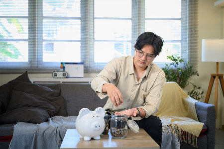 Man saving a money at living room.の写真素材