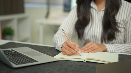 Closeup businesswoman hand working with writing on notebook.