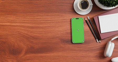 Flay lay, Top view office desk with green screen mobile phone, coffee, pencil, leaves with copy...