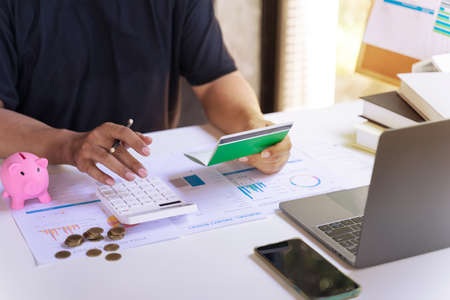 Financial planning and money saving concept. Business man hands holding saving account passbook and...