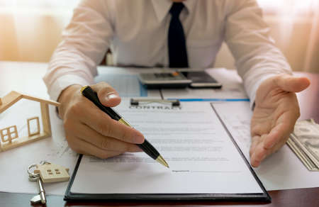 Bank officer or house seller agents showing point signature on the house purchase agreement. Real estate concept.の写真素材