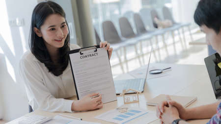 Women professional real estate agent show signing point on the contract agreement about house purchase contract, loan agreement, mortgage contract to Customers interested in buying a house. Portrait.の写真素材