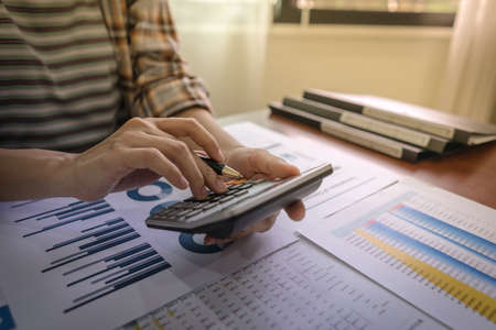 Close up of businesswoman or accountant using calculator for do math finance, Dedicated to the...