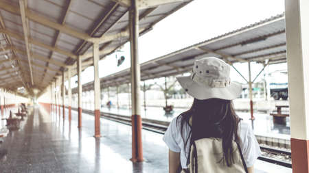 Banner Vintage style. Young female tourists with backpacks waiting for the train to travel at the train station. Travel and vacation conceptの写真素材