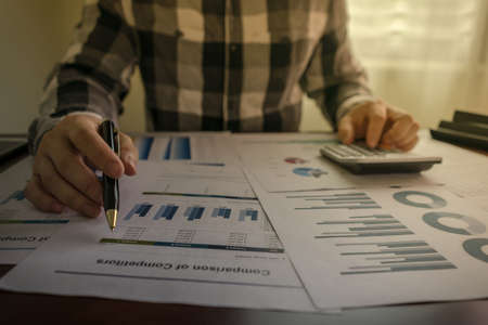 Close up, Businessman working calculate graph chart report marketing research development planning management strategy analysis financial accounting. statistics and analytic research conceptの写真素材