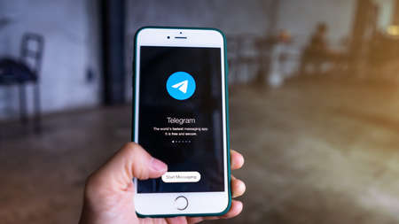 CHIANG MAI, THAILAND, August 1, 2021: Woman hand holding iPhone and using Telegram Application icon. Telegram is the fastest messaging app on the market.のeditorial素材
