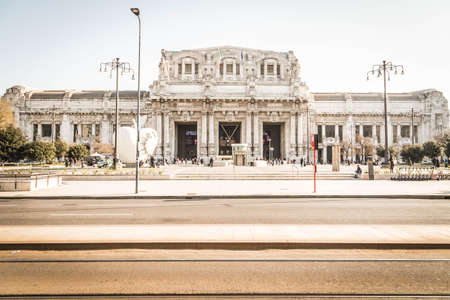 MILAN, ITALY - APRIL 12, 2022: Milan central train station building (Stazione Centrale) with people in front of the entrance in the early morning in Milan, Italy.のeditorial素材