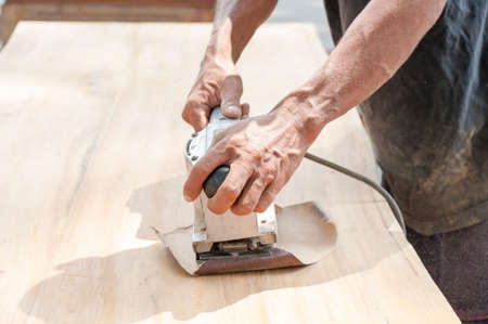 Hand of worker sanding the old wood table.の写真素材