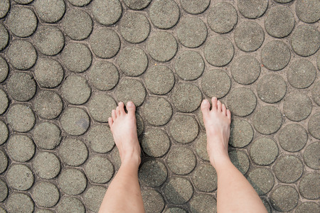 barefoot on patterned paving tiles, cement brick floor backgroundの写真素材