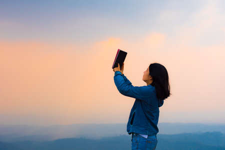 young woman selfie during Sunset on mountain with landscape view