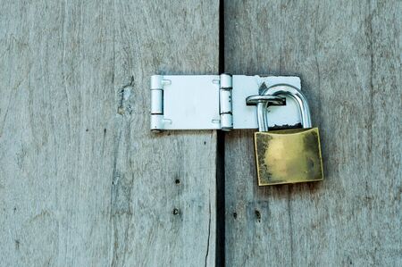 Old padlock on a wooden doorの写真素材