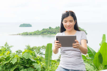 asian woman selfie with seascape against blue skyの写真素材
