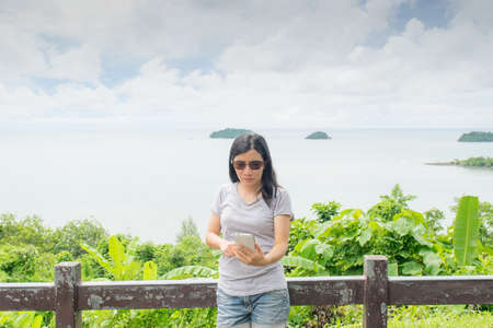asian woman selfie with seascape against blue skyの写真素材