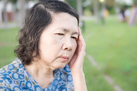 portrait of lonely senior asian woman in gardenの写真素材