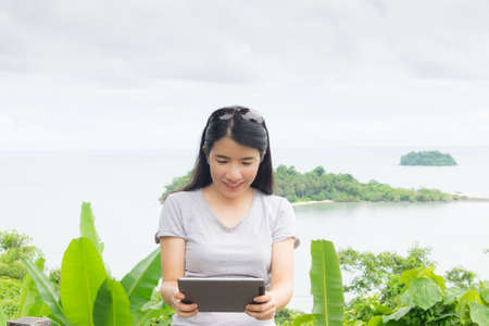 asian woman selfie with seascape against blue skyの写真素材