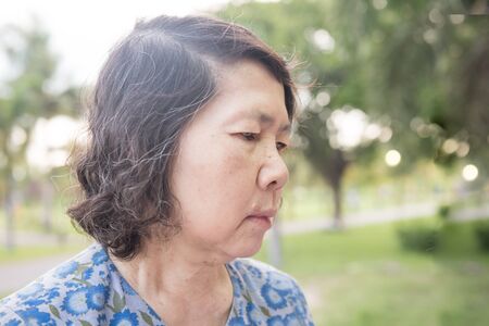 portrait of lonely senior asian woman in gardenの写真素材