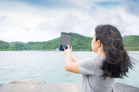 asian woman selfie with seascape against blue sky