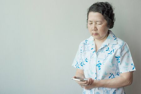 portrait of senior asian woman using smartphone and tabletの写真素材