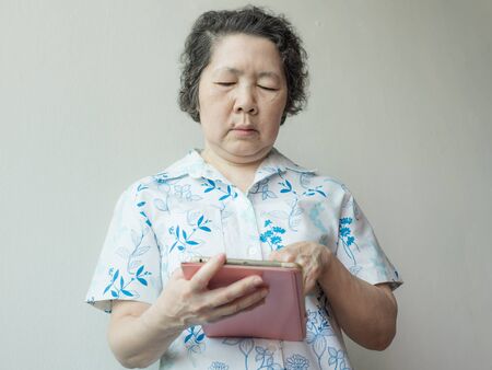 portrait of senior asian woman using smartphone and tabletの写真素材