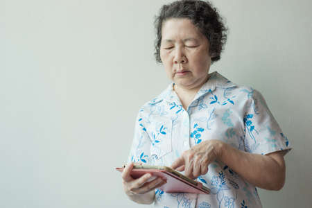 portrait of senior asian woman using smartphone and tabletの写真素材
