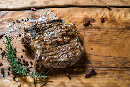 Fried steak on the bone on a wooden surfaceの写真素材