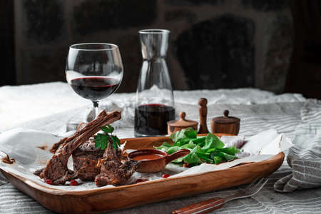 Grilled lamb loin on a wooden plate with wineの写真素材