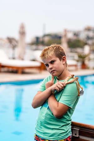 A boy shoots a slingshot near the poolの写真素材