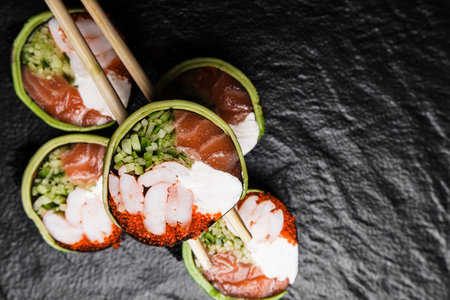 Fresh Sushi avocado shrimp Rolls Presenting Exquisitely on a Black Backgroundの写真素材