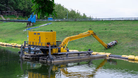 Brebes, Indonesia - Dec 12, 2021: A yellow excavator floating on water. This machine is heavy equipment used in the construction of the Malahayu reservoir.のeditorial素材