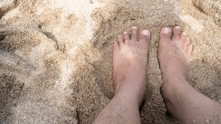 Picture of feet on a beach with a lot of white sand attachedの写真素材