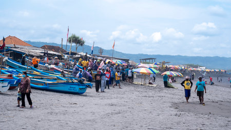 Yogyakarta, Indonesia - March 27, 2022: Activities on Depok beach while waiting for the fishermen to return from fishing in the blue seaのeditorial素材
