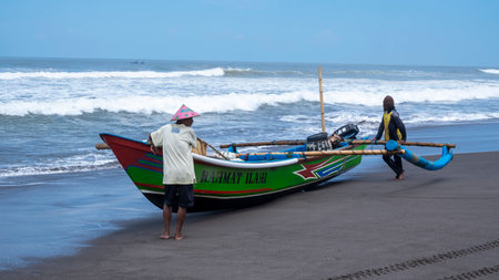 Yogyakarta, Indonesia - March 27, 2022: The fishermen prepare to go out into the blue sea for fishing by driving traditional small boatsのeditorial素材
