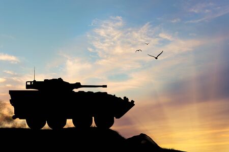 ?oncept of war. Silhouette military APCs at sunsetの写真素材