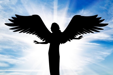 concept of religion. Silhouette of a beautiful angel with wings in the rays of light on the background of the skyの写真素材