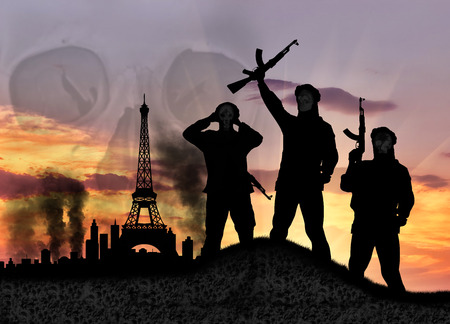 Concept of terrorism. Silhouette of the terrorists and the city in smoke against the sunsetの写真素材
