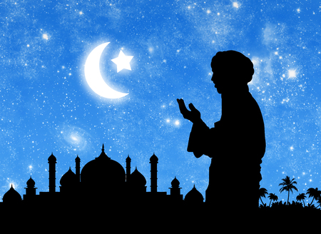 ?oncept of the Islamic religion. Silhouette of the town hall and praying men on the background of the starry sky and the moonの写真素材