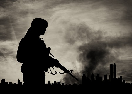 concept of terrorism. Silhouette terrorist on city background in smoke