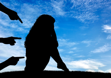Concept of deceit and betrayal. Silhouette of a woman and condemning the hands of people against the skyの写真素材