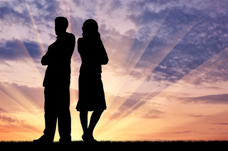Concept of betrayal and treason. Silhouette of man and woman in a quarrel at sunsetの写真素材