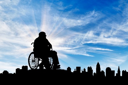 Concept of disability and old age. Silhouette of disabled person on a background of cityscape dayの写真素材