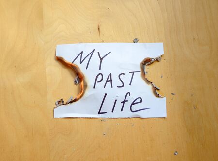 Concept of the beginning of a new life. Burning a piece of paper with the inscription