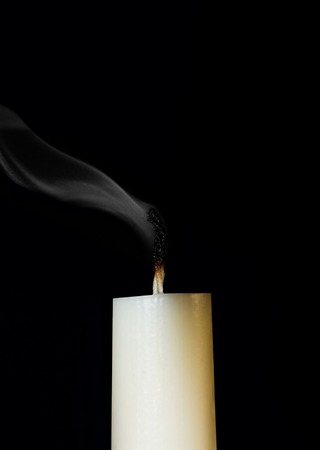 Ignition white candle. Isolated on a black backgroundの写真素材