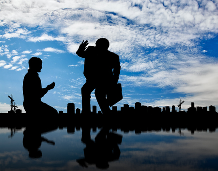 Social inequality. Silhouette of the rich and the poor man on the background cityscapeの写真素材