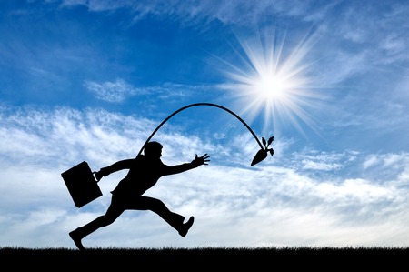 Silhouette of businessman running for the carrot. Concept of money and businessの写真素材