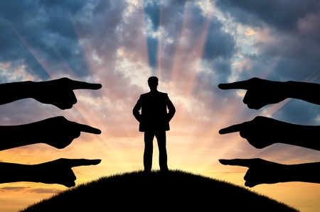 Discrimination and racism concept. Silhouette of hands of people point the finger at the manの写真素材