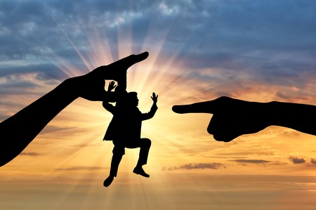 Feminism and discrimination. Silhouette, women's hands grabbed the little man condemning himの写真素材