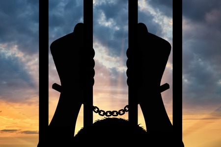 Freedom concept. Silhouette of human hands in handcuffs against the skyの写真素材