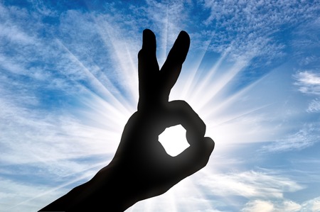 Success concept. Silhouette of man's hand shows the gesture OKの写真素材
