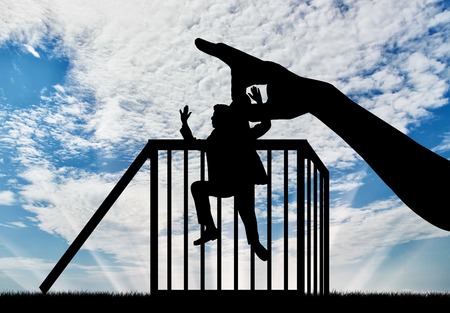 Feminism and discrimination. Female hand throws in a cage man silhouetteの写真素材
