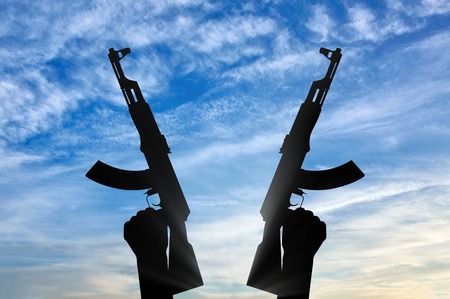 Terrorist concept. Weapons in the hands of terrorist, against the skyの写真素材